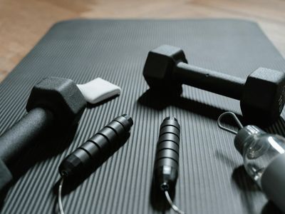 Black dumbbells lying on a textured sports mat